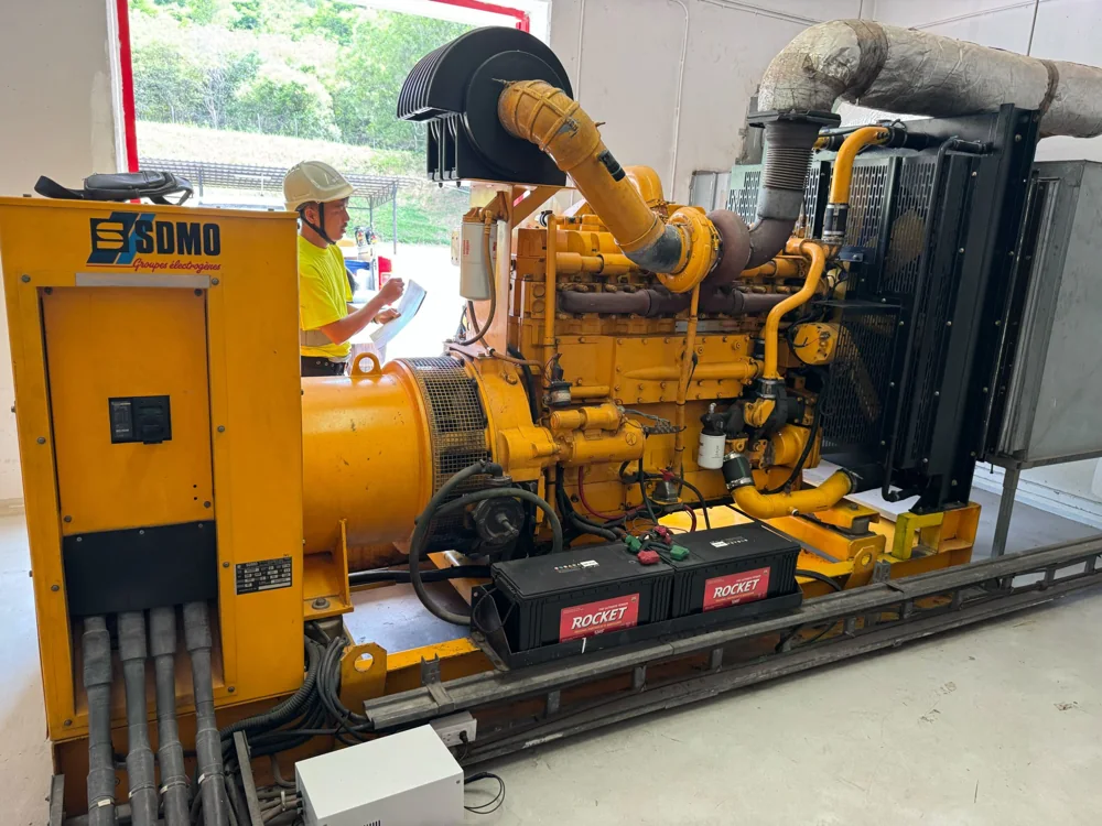 Generator and helmeted technician inspecting equipment